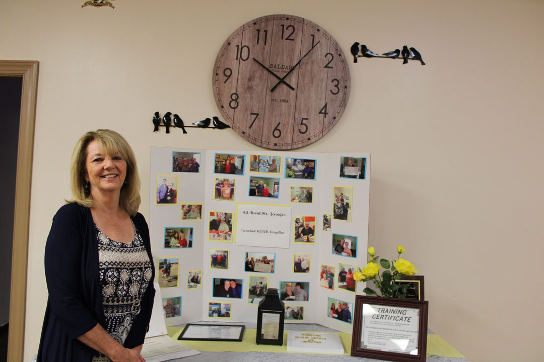 Helping Hands Executive Director Brigitte Stephens at a table dedicated to the memory of past Executive Director Jennifer Barbour (Photo by Karen Brewer, The Pickens County Chronicle)