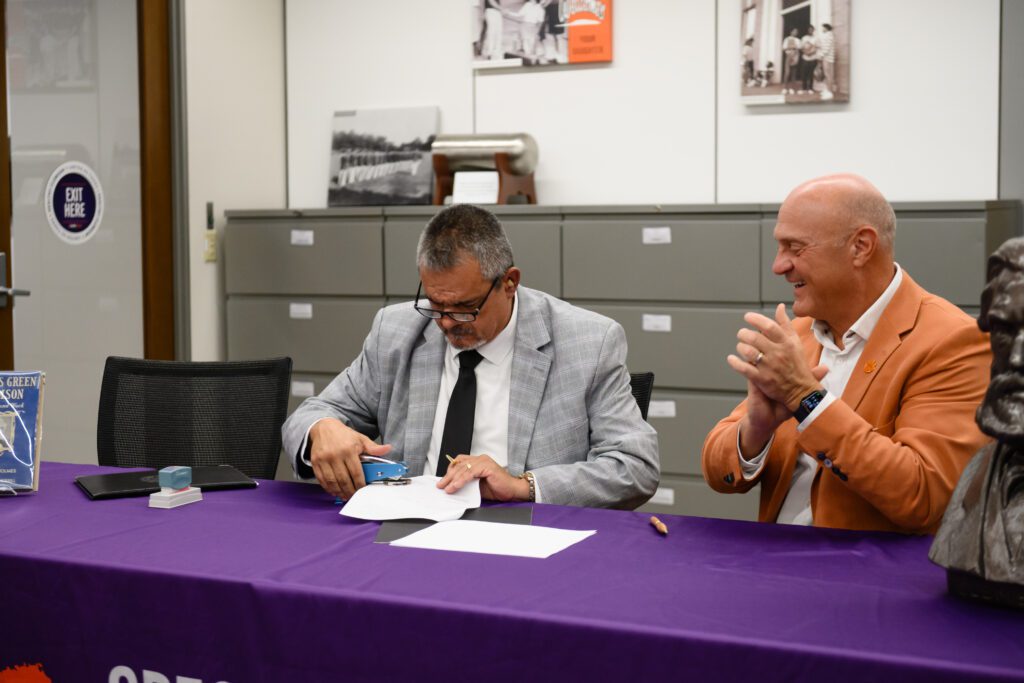 Oconee County Probate Judge Danny Singleton (left) notorizes the paperwork for the long-term loan of Thomas Green Clemson's will as Clemson University President Jim Clements looks on (Photo from Clemson University)