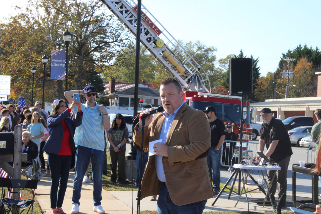 Rev. Travis McAlister, of Golden Creek Baptist Church, introduces the veterans in the parade (Photo by Karen Brewer, The Pickens County Chronicle)