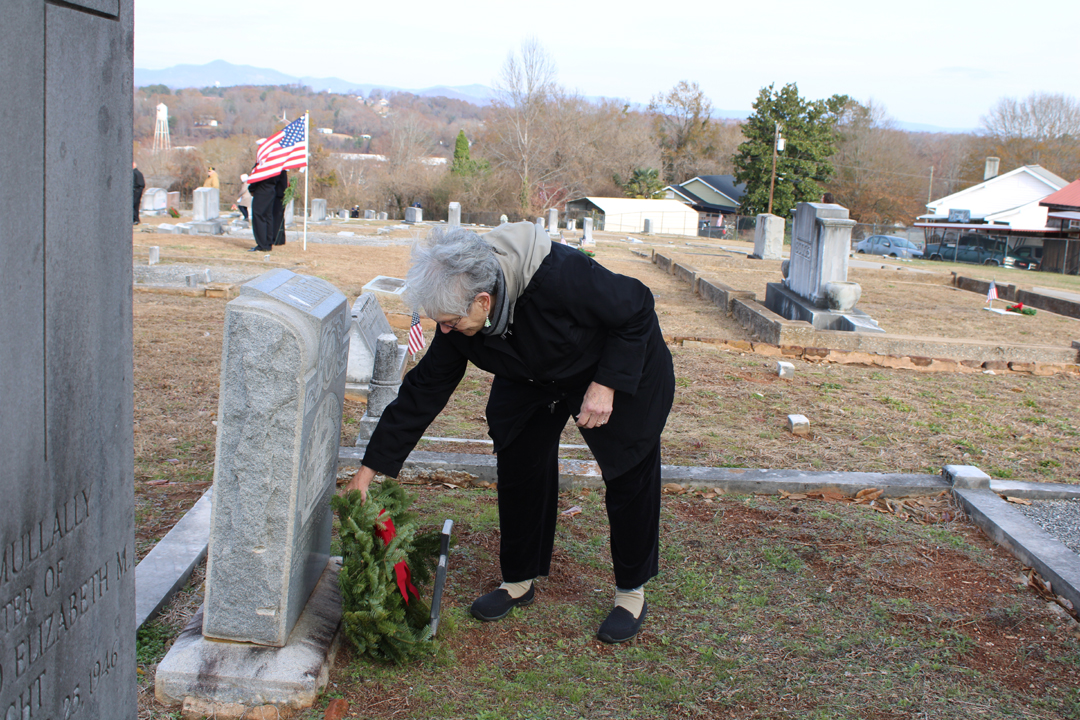 Linda Starin, Treasurer of The Pickens County Historical Society, lays a wreath on a veteran's grave. (Photo by Karen Brewer, The Pickens County Chronicle)