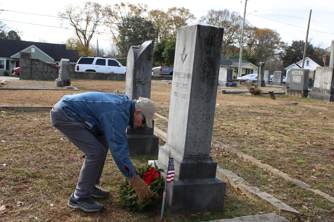 Richard Painter, Pickens Vice President of the Pickens County Historical Society, lays a wreath on a veteran's grave. (Photo by Karen Brewer, The Pickens County Chronicle)