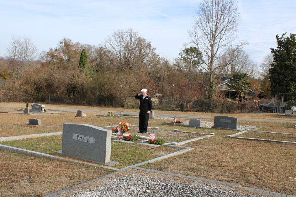 A US Naval Sea Cadet salutes after laying a wreath at a veteran's grave. (Photo by Karen Brewer, The Pickens County Chronicle)