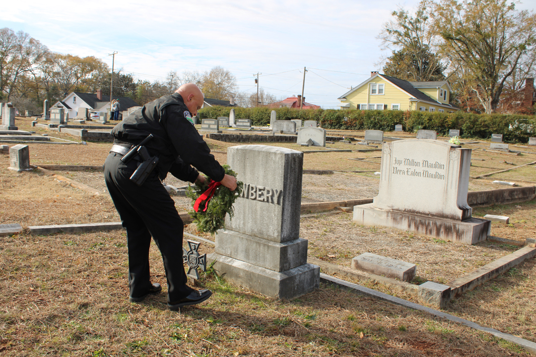 Chief Beach lays a wreath on a veteran's grave. (Photo by Karen Brewer, The Pickens County Chronicle))