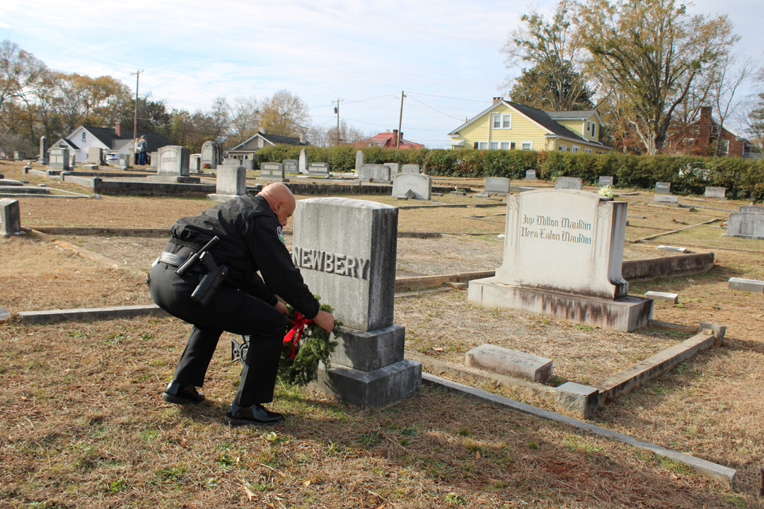 Chief Beach lays a wreath on a veteran's grave. (Photo by Karen Brewer, The Pickens County Chronicle)