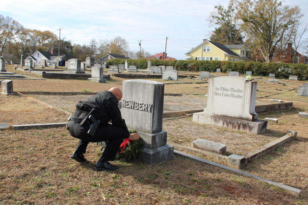 Chief Beach lays a wreath on a veteran's grave. (Photo by Karen Brewer, The Pickens County Chronicle)