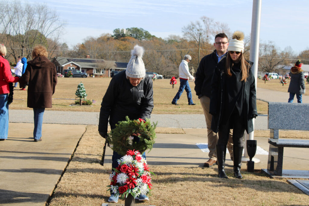 Pat Holtzclaw, Vice President of Liberty Mortuary, places a wreath. (Photo by Karen Brewer, The Pickens County Chronicle)