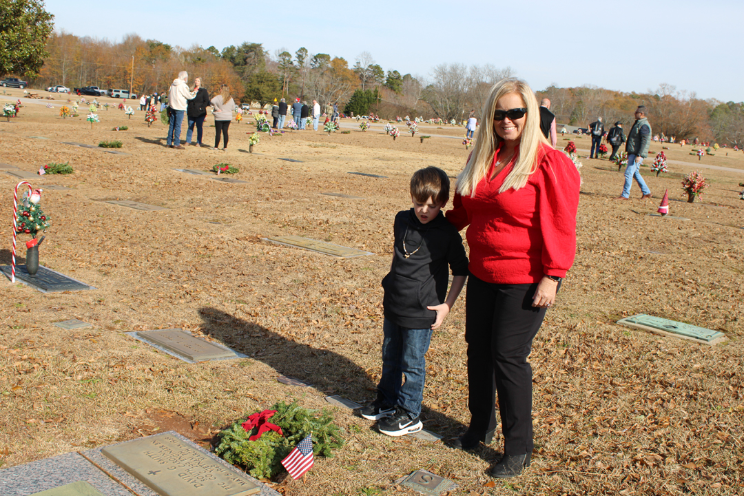 Amy Barrett with grandson Easton Barrett after placing a wreath. (Photo by Karen Brewer, The Pickens County Chronicle)