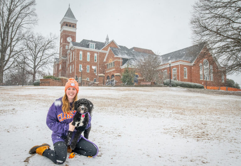 Abigail Lefler, a senior studying industrial engineering from Denver, NC, and her dog, Kudzoo, play in the snow on Bowman Field during the first snow storm on campus in three years, January 10, 2025. (Photo by Ken Scar, Clemson University)