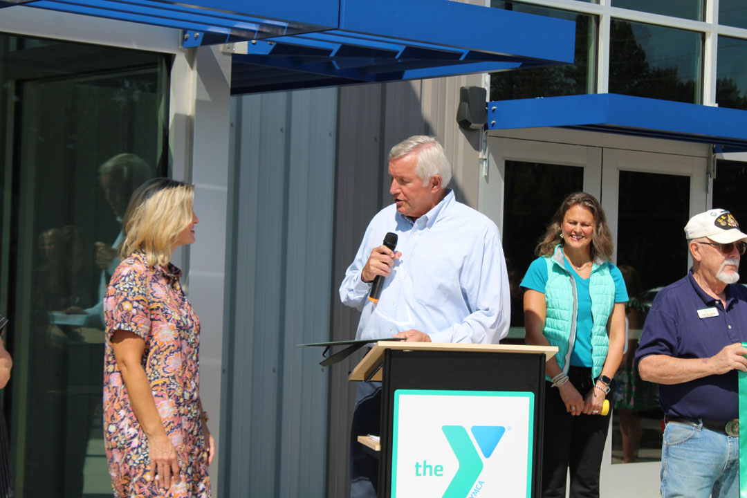 Rick Cothran, Director of Membership and Engagement with the Easley Chamber of Commerce, presents Kim Valentin with a gift of $1 from the Easley Chamber of Commerce. (Photo by Karen Brewer, The Pickens County Chronicle)