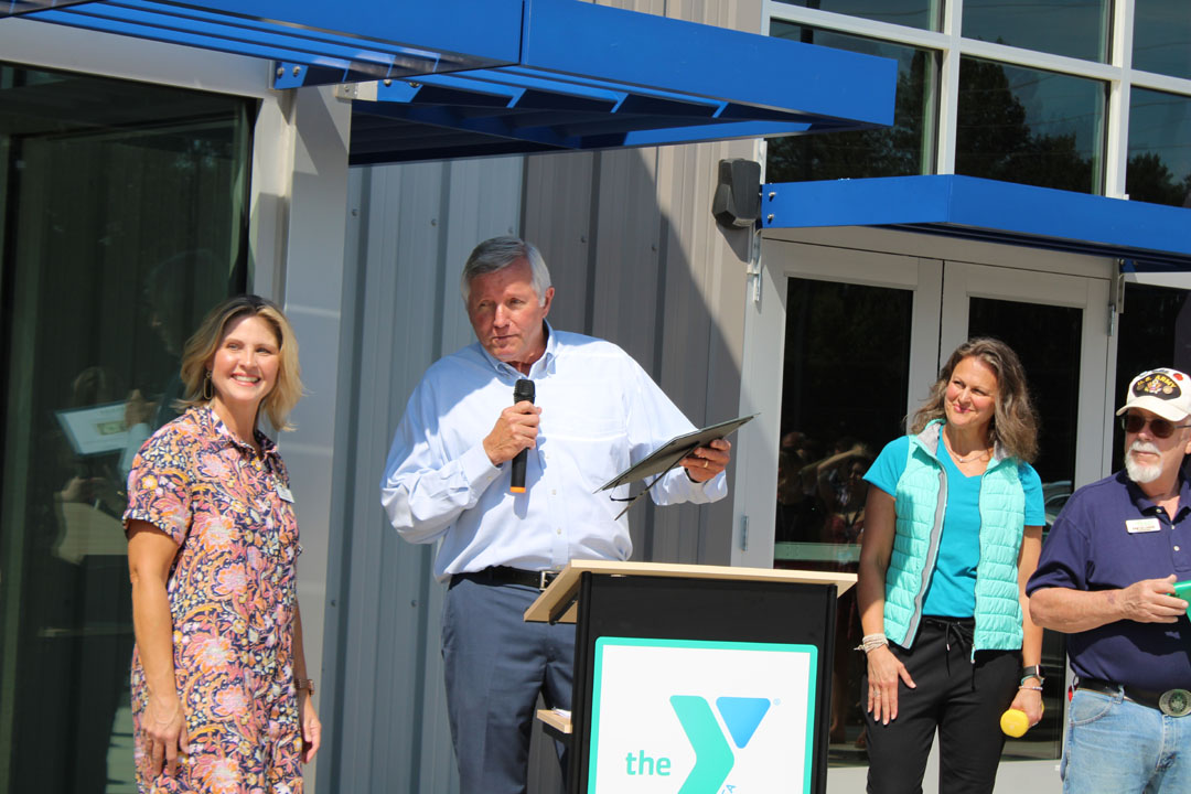 Rick Cothran, Director of Membership and Engagement with the Easley Chamber of Commerce, presents Kim Valentin with a gift of $1 from the Easley Chamber of Commerce. (Photo by Karen Brewer, The Pickens County Chronicle)