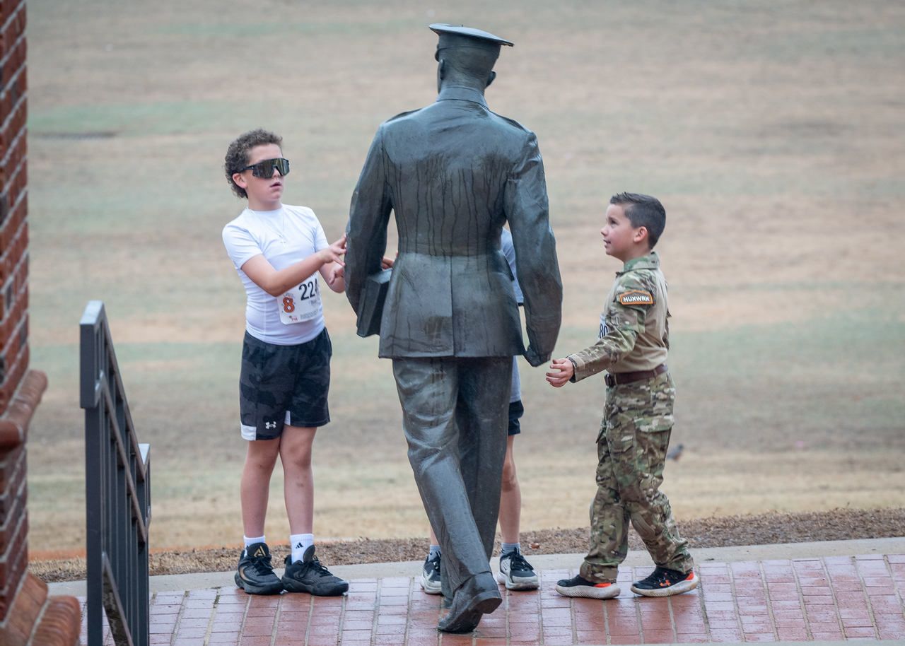 Hundreds of people participate in the 2026 Clemson 8 Challenge, an eight-mile run/walk/ruck march, on a misty Saturday morning, March 7, 2026. The Challenge was created to honor the 25 known Clemson alumni who suffered as POWs in all wars. It was originally created for 1938 Clemson alumnus, professor emeritus and WWII hero Ben Skardon, a survivor of the Bataan Death March, but has expanded to include Clemson POWs from all wars. Money raised from the event goes toward sending teams of Clemson ROTC students to participate in the Bataan Memorial Death March at White Sands Missile Range, NM. Sophomore finance major GB Stalnaker served as master of ceremonies. (Photo by Ken Scar)