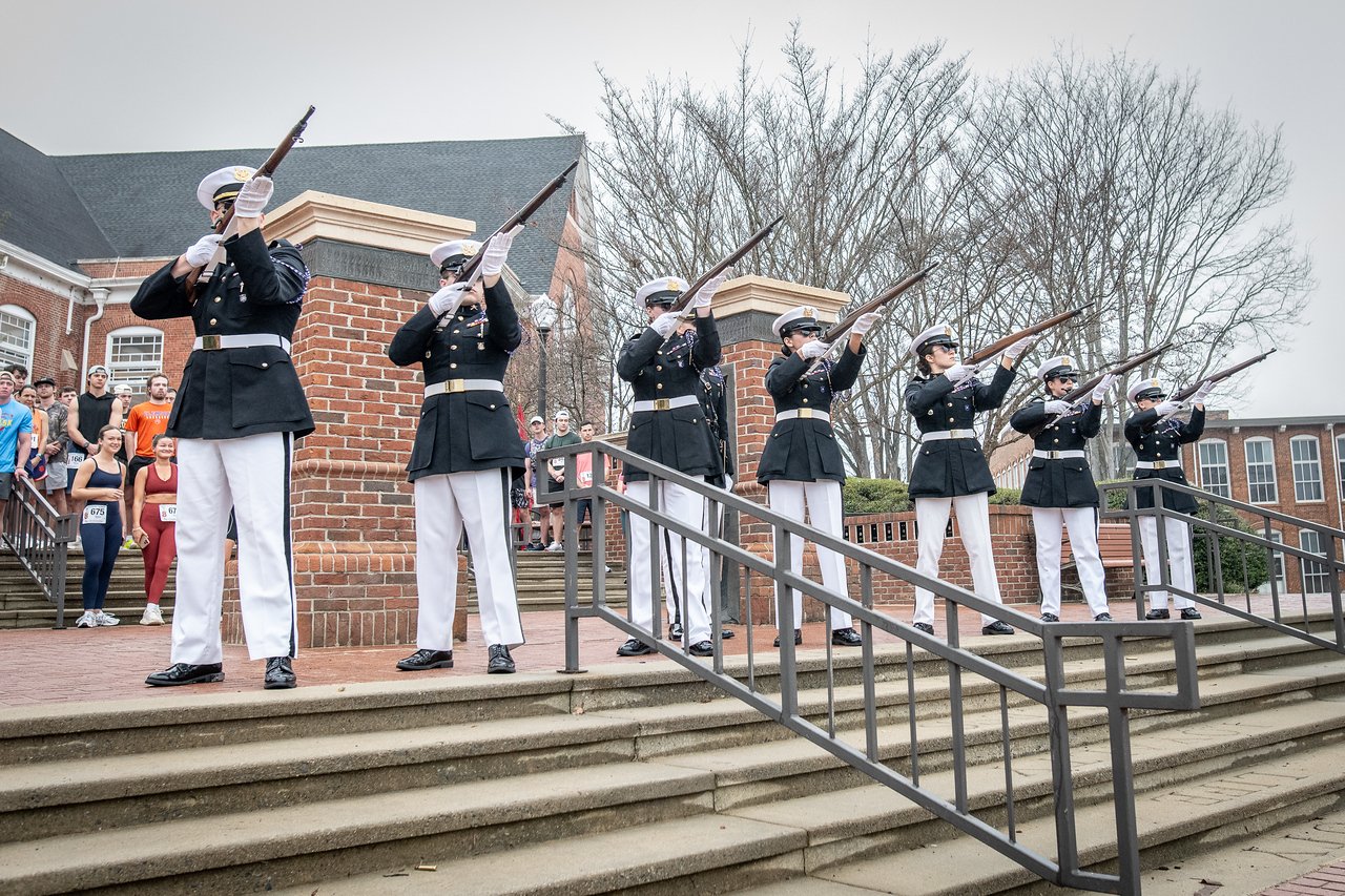 Hundreds of people participate in the 2026 Clemson 8 Challenge, an eight-mile run/walk/ruck march, on a misty Saturday morning, March 7, 2026. The Challenge was created to honor the 25 known Clemson alumni who suffered as POWs in all wars. It was originally created for 1938 Clemson alumnus, professor emeritus and WWII hero Ben Skardon, a survivor of the Bataan Death March, but has expanded to include Clemson POWs from all wars. Money raised from the event goes toward sending teams of Clemson ROTC students to participate in the Bataan Memorial Death March at White Sands Missile Range, NM. Sophomore finance major GB Stalnaker served as master of ceremonies. (Photo by Ken Scar)