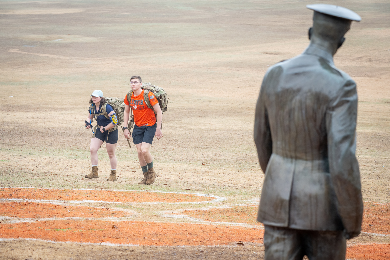 Hundreds of people participate in the 2026 Clemson 8 Challenge, an eight-mile run/walk/ruck march, on a misty Saturday morning, March 7, 2026. The Challenge was created to honor the 25 known Clemson alumni who suffered as POWs in all wars. It was originally created for 1938 Clemson alumnus, professor emeritus and WWII hero Ben Skardon, a survivor of the Bataan Death March, but has expanded to include Clemson POWs from all wars. Money raised from the event goes toward sending teams of Clemson ROTC students to participate in the Bataan Memorial Death March at White Sands Missile Range, NM. Sophomore finance major GB Stalnaker served as master of ceremonies. (Photo by Ken Scar)