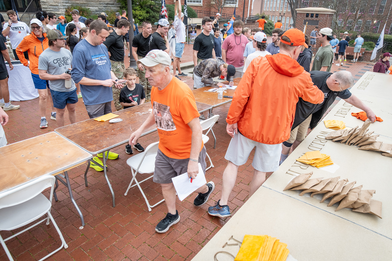 Hundreds of people participate in the 2026 Clemson 8 Challenge, an eight-mile run/walk/ruck march, on a misty Saturday morning, March 7, 2026. The Challenge was created to honor the 25 known Clemson alumni who suffered as POWs in all wars. It was originally created for 1938 Clemson alumnus, professor emeritus and WWII hero Ben Skardon, a survivor of the Bataan Death March, but has expanded to include Clemson POWs from all wars. Money raised from the event goes toward sending teams of Clemson ROTC students to participate in the Bataan Memorial Death March at White Sands Missile Range, NM. Sophomore finance major GB Stalnaker served as master of ceremonies. (Photo by Ken Scar)