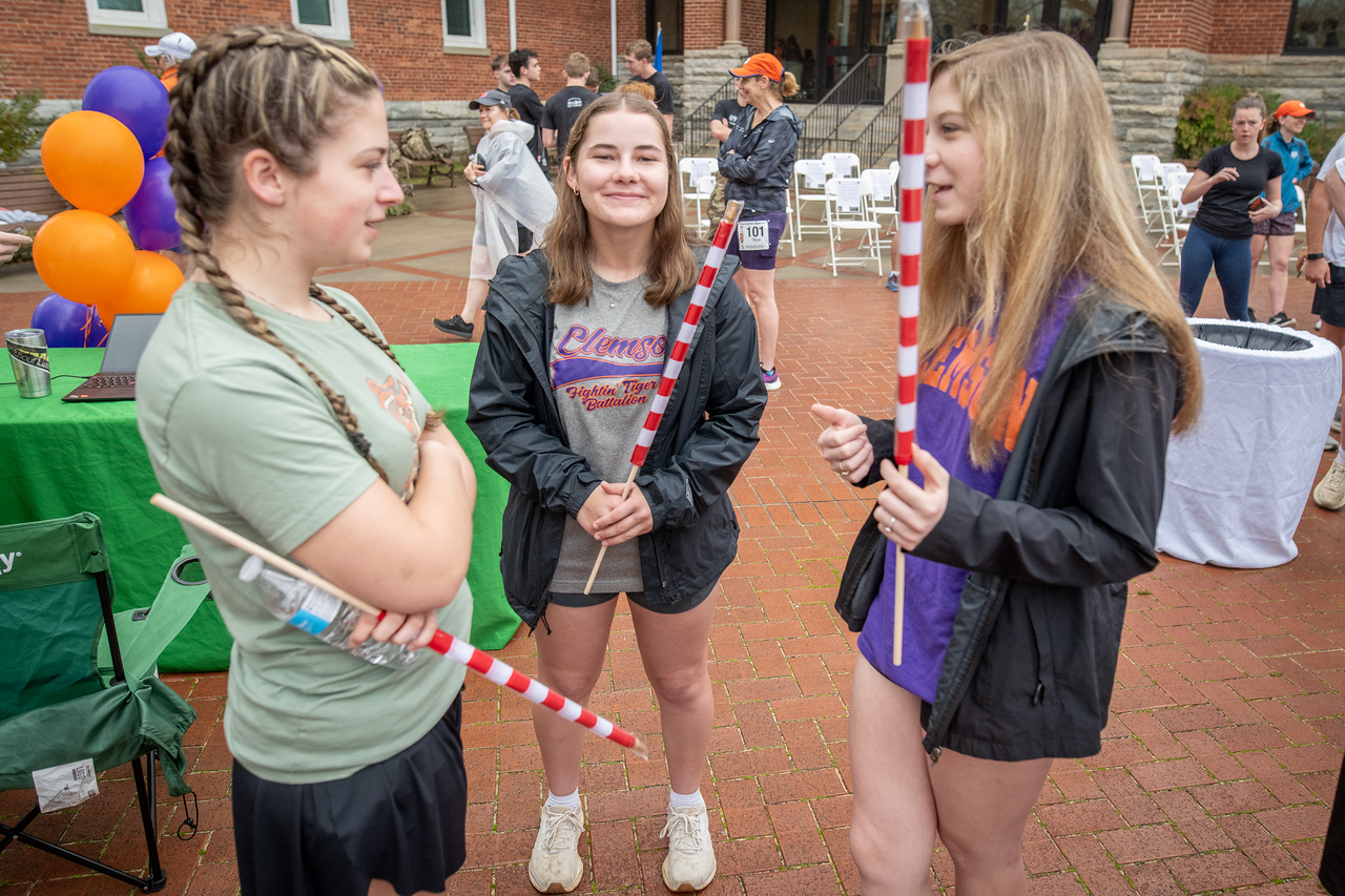Hundreds of people participate in the 2026 Clemson 8 Challenge, an eight-mile run/walk/ruck march, on a misty Saturday morning, March 7, 2026. The Challenge was created to honor the 25 known Clemson alumni who suffered as POWs in all wars. It was originally created for 1938 Clemson alumnus, professor emeritus and WWII hero Ben Skardon, a survivor of the Bataan Death March, but has expanded to include Clemson POWs from all wars. Money raised from the event goes toward sending teams of Clemson ROTC students to participate in the Bataan Memorial Death March at White Sands Missile Range, NM. Sophomore finance major GB Stalnaker served as master of ceremonies. (Photo by Ken Scar)
