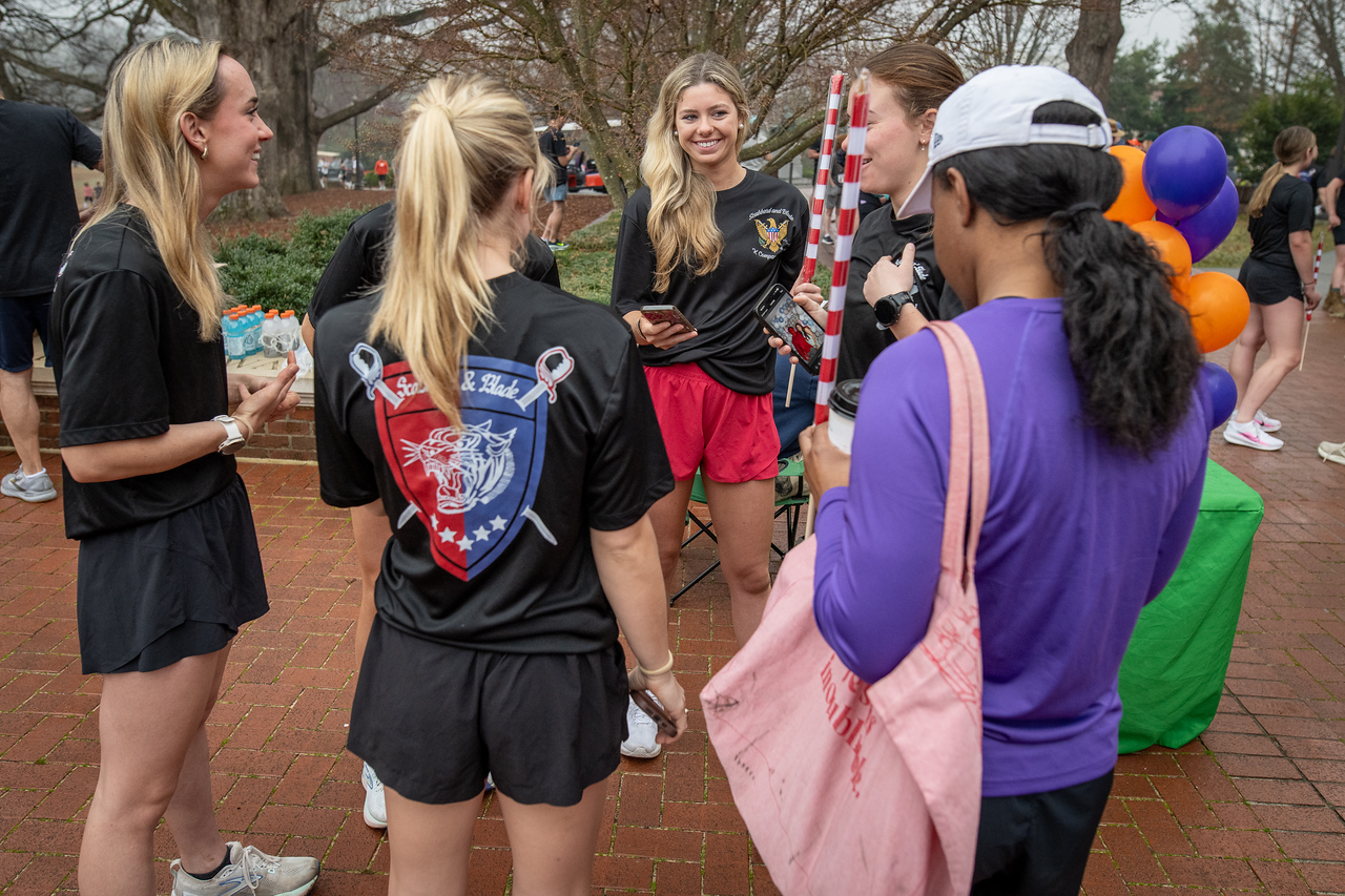 Hundreds of people participate in the 2026 Clemson 8 Challenge, an eight-mile run/walk/ruck march, on a misty Saturday morning, March 7, 2026. The Challenge was created to honor the 25 known Clemson alumni who suffered as POWs in all wars. It was originally created for 1938 Clemson alumnus, professor emeritus and WWII hero Ben Skardon, a survivor of the Bataan Death March, but has expanded to include Clemson POWs from all wars. Money raised from the event goes toward sending teams of Clemson ROTC students to participate in the Bataan Memorial Death March at White Sands Missile Range, NM. Sophomore finance major GB Stalnaker served as master of ceremonies. (Photo by Ken Scar)
