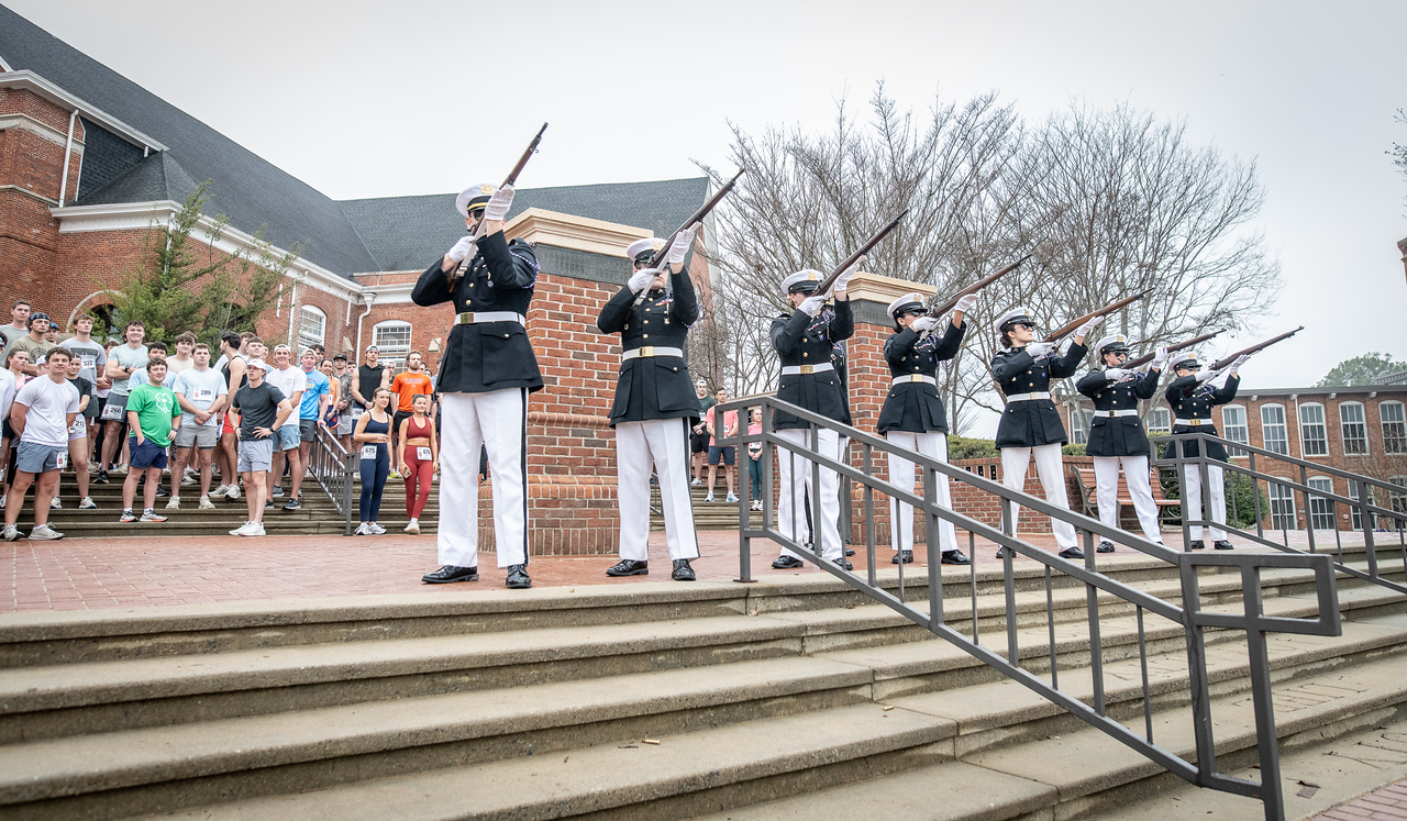Hundreds of people participate in the 2026 Clemson 8 Challenge, an eight-mile run/walk/ruck march, on a misty Saturday morning, March 7, 2026. The Challenge was created to honor the 25 known Clemson alumni who suffered as POWs in all wars. It was originally created for 1938 Clemson alumnus, professor emeritus and WWII hero Ben Skardon, a survivor of the Bataan Death March, but has expanded to include Clemson POWs from all wars. Money raised from the event goes toward sending teams of Clemson ROTC students to participate in the Bataan Memorial Death March at White Sands Missile Range, NM. Sophomore finance major GB Stalnaker served as master of ceremonies. (Photo by Ken Scar)
