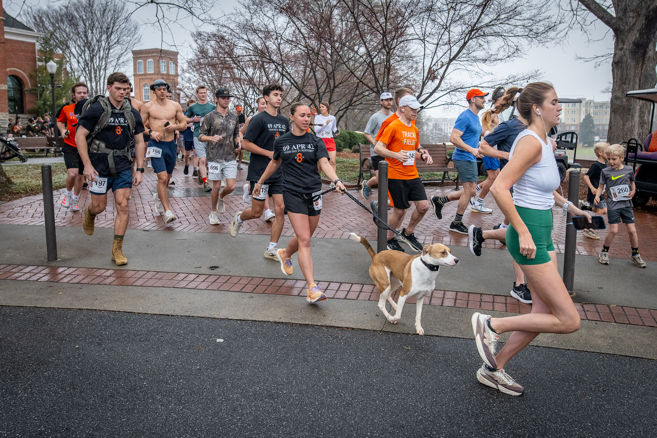 Hundreds of people participate in the 2026 Clemson 8 Challenge, an eight-mile run/walk/ruck march, on a misty Saturday morning, March 7, 2026. The Challenge was created to honor the 25 known Clemson alumni who suffered as POWs in all wars. It was originally created for 1938 Clemson alumnus, professor emeritus and WWII hero Ben Skardon, a survivor of the Bataan Death March, but has expanded to include Clemson POWs from all wars. Money raised from the event goes toward sending teams of Clemson ROTC students to participate in the Bataan Memorial Death March at White Sands Missile Range, NM. Sophomore finance major GB Stalnaker served as master of ceremonies. (Photo by Ken Scar)