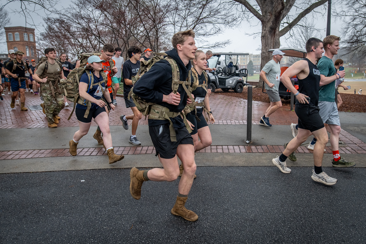 Hundreds of people participate in the 2026 Clemson 8 Challenge, an eight-mile run/walk/ruck march, on a misty Saturday morning, March 7, 2026. The Challenge was created to honor the 25 known Clemson alumni who suffered as POWs in all wars. It was originally created for 1938 Clemson alumnus, professor emeritus and WWII hero Ben Skardon, a survivor of the Bataan Death March, but has expanded to include Clemson POWs from all wars. Money raised from the event goes toward sending teams of Clemson ROTC students to participate in the Bataan Memorial Death March at White Sands Missile Range, NM. Sophomore finance major GB Stalnaker served as master of ceremonies. (Photo by Ken Scar)