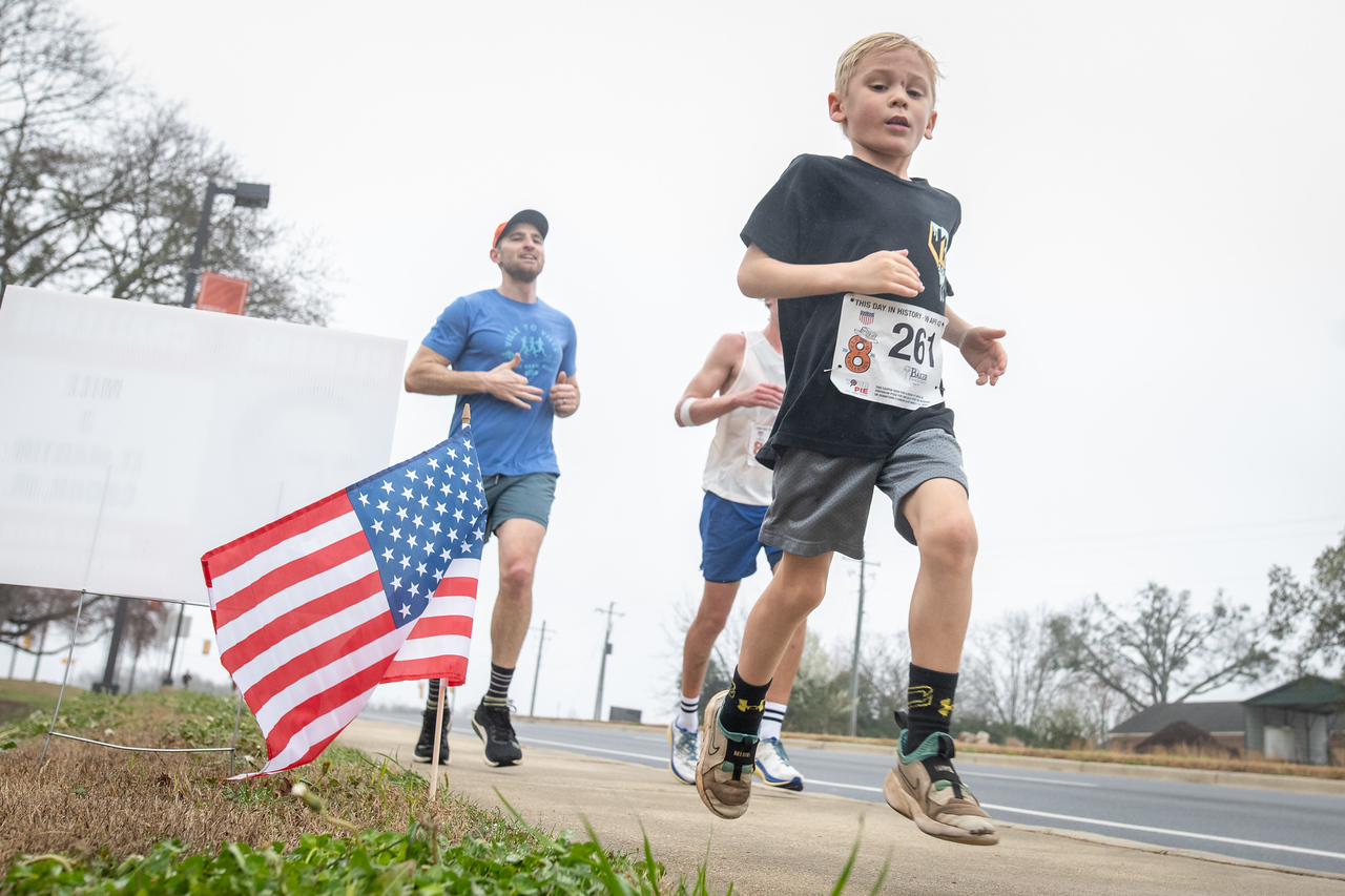 Hundreds of people participate in the 2026 Clemson 8 Challenge, an eight-mile run/walk/ruck march, on a misty Saturday morning, March 7, 2026. The Challenge was created to honor the 25 known Clemson alumni who suffered as POWs in all wars. It was originally created for 1938 Clemson alumnus, professor emeritus and WWII hero Ben Skardon, a survivor of the Bataan Death March, but has expanded to include Clemson POWs from all wars. Money raised from the event goes toward sending teams of Clemson ROTC students to participate in the Bataan Memorial Death March at White Sands Missile Range, NM. Sophomore finance major GB Stalnaker served as master of ceremonies. (Photo by Ken Scar)