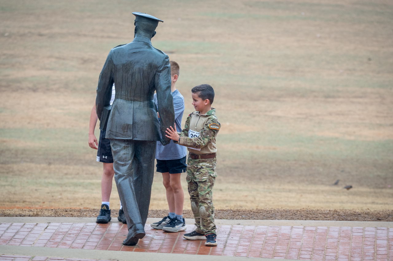Hundreds of people participate in the 2026 Clemson 8 Challenge, an eight-mile run/walk/ruck march, on a misty Saturday morning, March 7, 2026. The Challenge was created to honor the 25 known Clemson alumni who suffered as POWs in all wars. It was originally created for 1938 Clemson alumnus, professor emeritus and WWII hero Ben Skardon, a survivor of the Bataan Death March, but has expanded to include Clemson POWs from all wars. Money raised from the event goes toward sending teams of Clemson ROTC students to participate in the Bataan Memorial Death March at White Sands Missile Range, NM. Sophomore finance major GB Stalnaker served as master of ceremonies. (Photo by Ken Scar)
