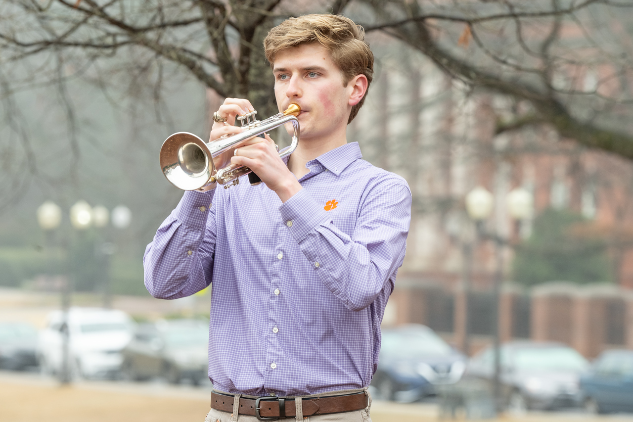 Hundreds of people participate in the 2026 Clemson 8 Challenge, an eight-mile run/walk/ruck march, on a misty Saturday morning, March 7, 2026. The Challenge was created to honor the 25 known Clemson alumni who suffered as POWs in all wars. It was originally created for 1938 Clemson alumnus, professor emeritus and WWII hero Ben Skardon, a survivor of the Bataan Death March, but has expanded to include Clemson POWs from all wars. Money raised from the event goes toward sending teams of Clemson ROTC students to participate in the Bataan Memorial Death March at White Sands Missile Range, NM. Sophomore finance major GB Stalnaker served as master of ceremonies. (Photo by Ken Scar)