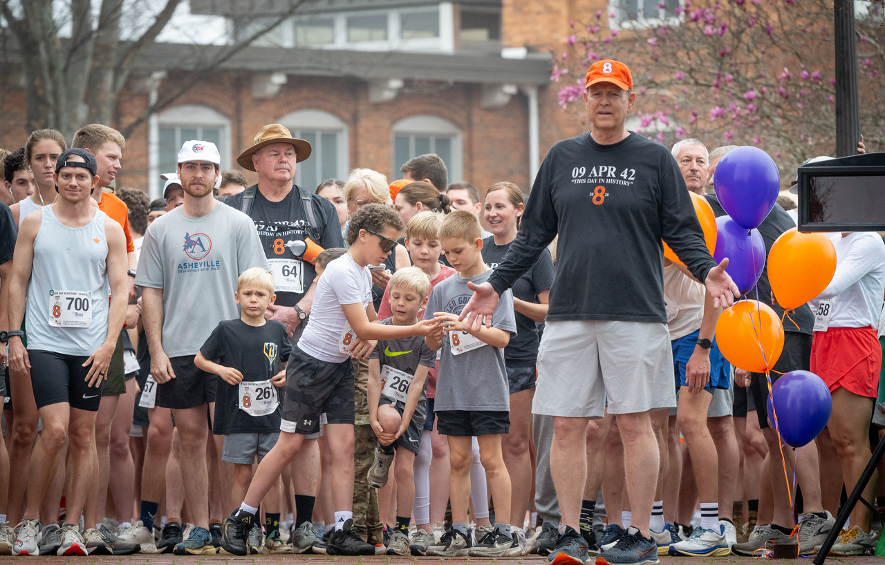Hundreds of people participate in the 2026 Clemson 8 Challenge, an eight-mile run/walk/ruck march, on a misty Saturday morning, March 7, 2026. The Challenge was created to honor the 25 known Clemson alumni who suffered as POWs in all wars. It was originally created for 1938 Clemson alumnus, professor emeritus and WWII hero Ben Skardon, a survivor of the Bataan Death March, but has expanded to include Clemson POWs from all wars. Money raised from the event goes toward sending teams of Clemson ROTC students to participate in the Bataan Memorial Death March at White Sands Missile Range, NM. Sophomore finance major GB Stalnaker served as master of ceremonies. (Photo by Ken Scar)