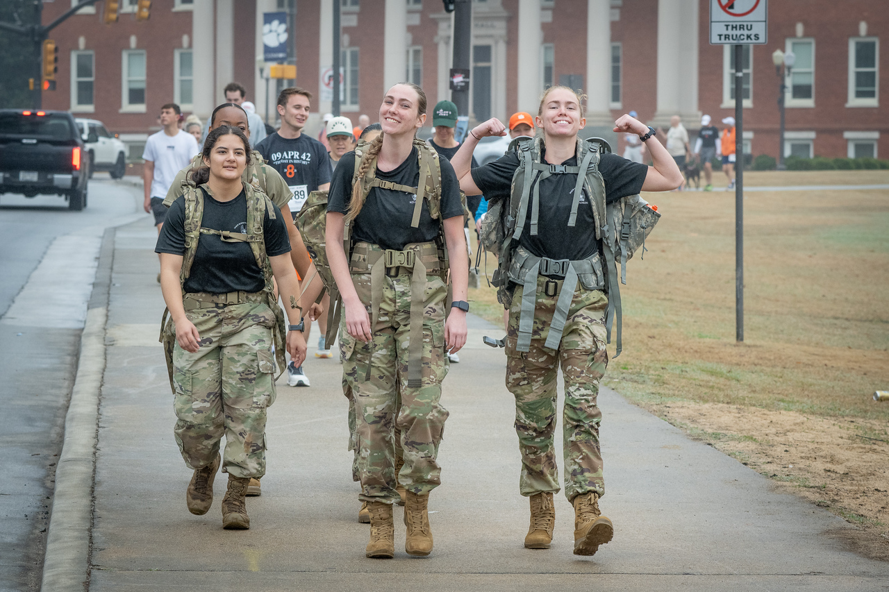 Hundreds of people participate in the 2026 Clemson 8 Challenge, an eight-mile run/walk/ruck march, on a misty Saturday morning, March 7, 2026. The Challenge was created to honor the 25 known Clemson alumni who suffered as POWs in all wars. It was originally created for 1938 Clemson alumnus, professor emeritus and WWII hero Ben Skardon, a survivor of the Bataan Death March, but has expanded to include Clemson POWs from all wars. Money raised from the event goes toward sending teams of Clemson ROTC students to participate in the Bataan Memorial Death March at White Sands Missile Range, NM. Sophomore finance major GB Stalnaker served as master of ceremonies. (Photo by Ken Scar)