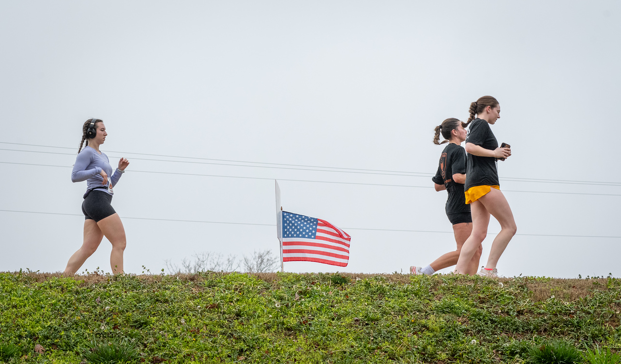 Hundreds of people participate in the 2026 Clemson 8 Challenge, an eight-mile run/walk/ruck march, on a misty Saturday morning, March 7, 2026. The Challenge was created to honor the 25 known Clemson alumni who suffered as POWs in all wars. It was originally created for 1938 Clemson alumnus, professor emeritus and WWII hero Ben Skardon, a survivor of the Bataan Death March, but has expanded to include Clemson POWs from all wars. Money raised from the event goes toward sending teams of Clemson ROTC students to participate in the Bataan Memorial Death March at White Sands Missile Range, NM. Sophomore finance major GB Stalnaker served as master of ceremonies. (Photo by Ken Scar)