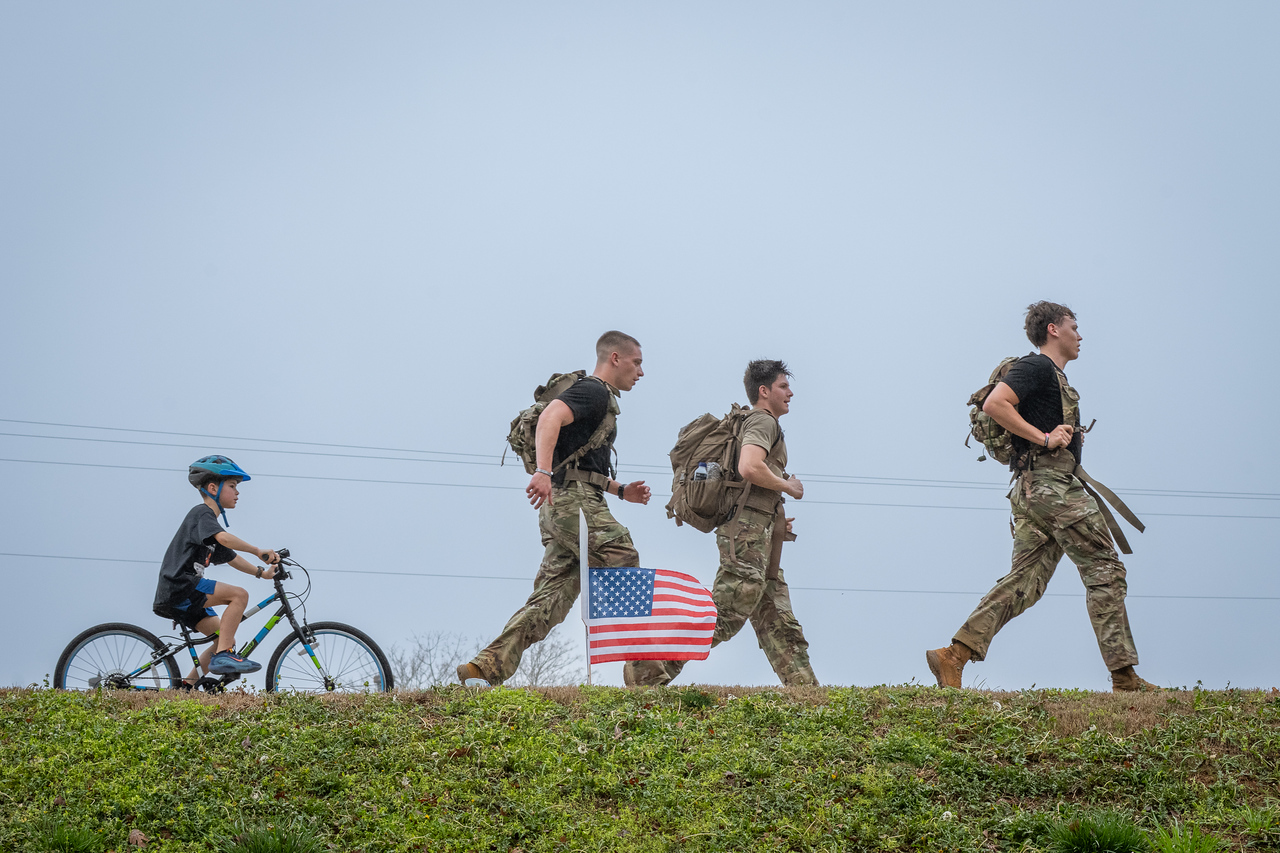 Hundreds of people participate in the 2026 Clemson 8 Challenge, an eight-mile run/walk/ruck march, on a misty Saturday morning, March 7, 2026. The Challenge was created to honor the 25 known Clemson alumni who suffered as POWs in all wars. It was originally created for 1938 Clemson alumnus, professor emeritus and WWII hero Ben Skardon, a survivor of the Bataan Death March, but has expanded to include Clemson POWs from all wars. Money raised from the event goes toward sending teams of Clemson ROTC students to participate in the Bataan Memorial Death March at White Sands Missile Range, NM. Sophomore finance major GB Stalnaker served as master of ceremonies. (Photo by Ken Scar)