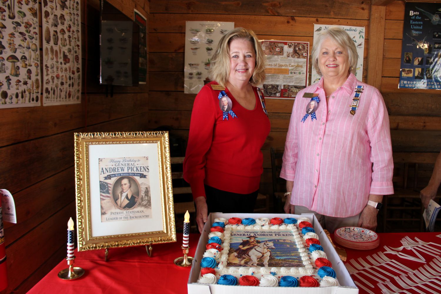 Sisters Julie Mays Thompson and Dianne Mays Crooks, descendants of General Andrew Pickens, pose with the birthday cake. (Photo by Karen Brewer, The Pickens County Chronicle)