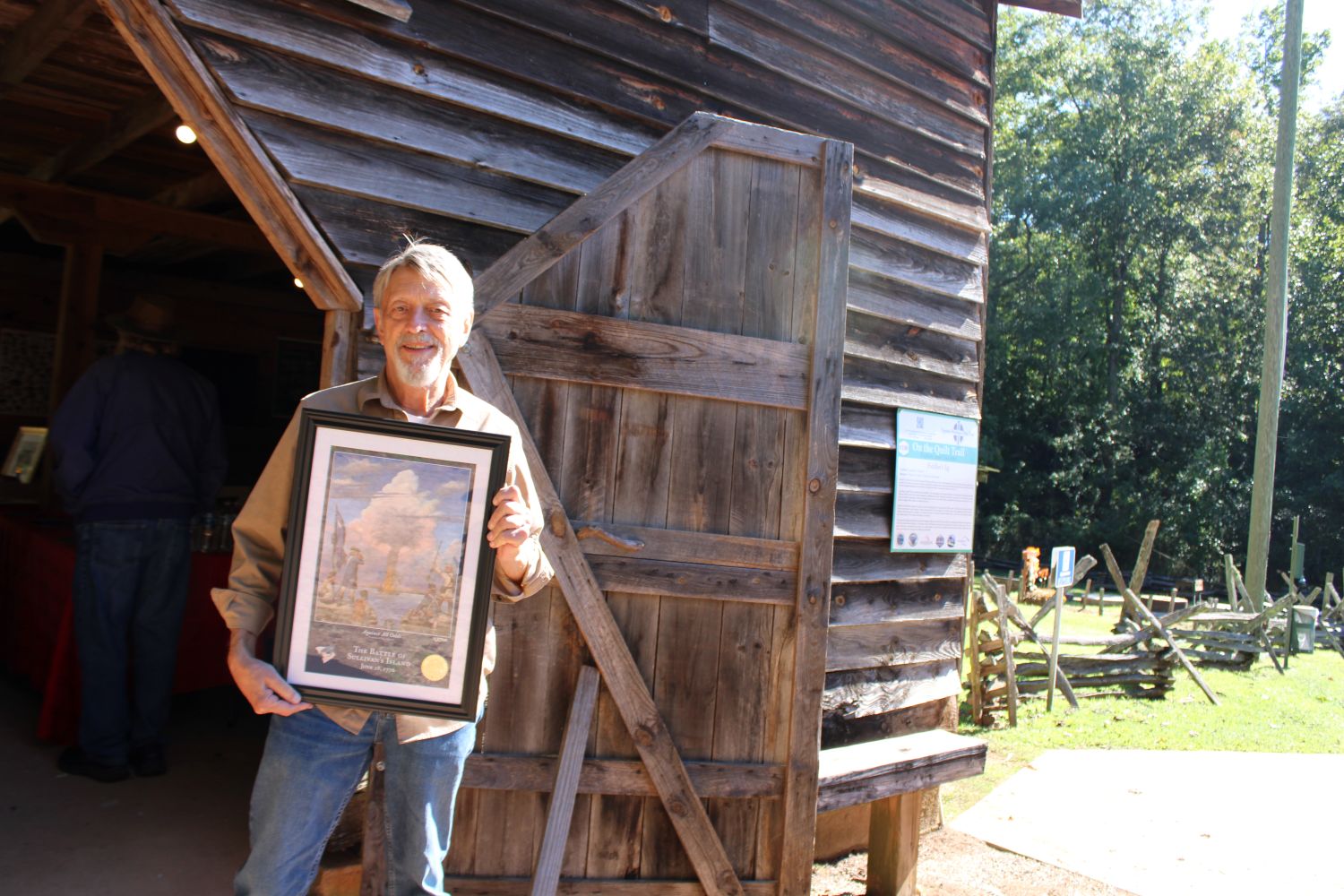 Pickens County Historical Society Senior Vice President Wayne Kelley holds the print presented by Heather Thompson from Clemson University Historic Properties. (Photo by Karen Brewer, The Pickens County Chronicle)