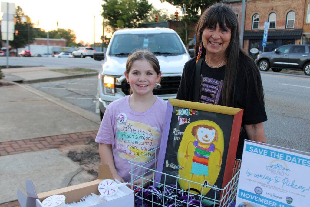 Emberly Nicholson (who designed the artwork pictured) and her aunt, Tricia Griffin, prior to the start of the candlelight vigil ceremony on Thursday, October 1, 2026. (Photo by Karen Brewer, The Pickens County Chronicle)
